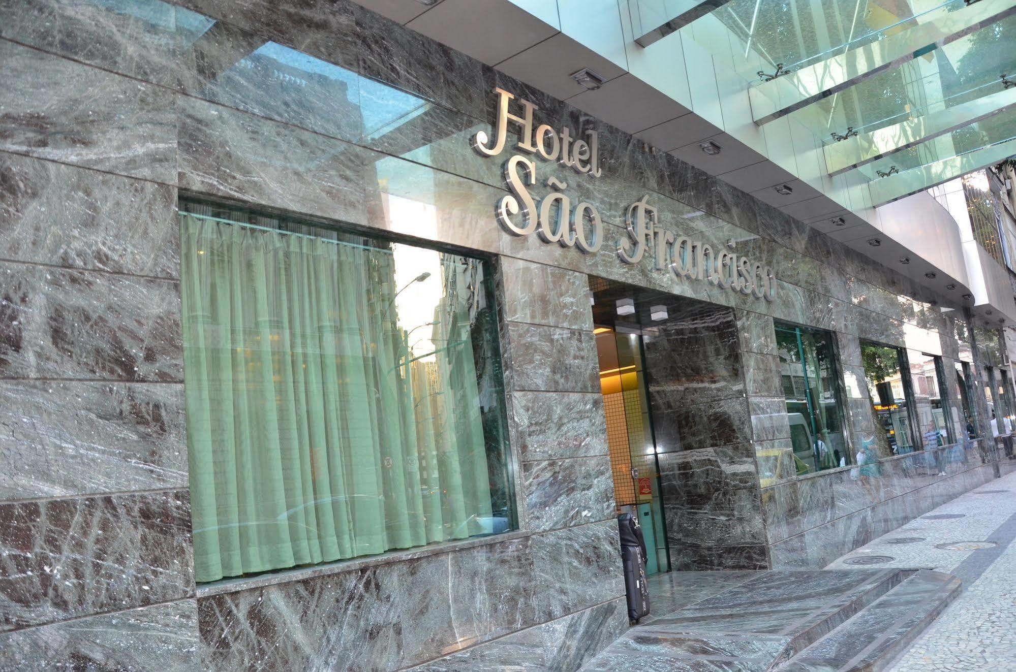 ריו דה ז'ניירו Hotel Atlantico Tower מראה חיצוני תמונה The photo shows the exterior of a hotel named "Hotel São Francisco." The facade is made of marble, giving it an elegant appearance, and large glass windows are visible, likely allowing natural light to enter the interior. There are light green curtai